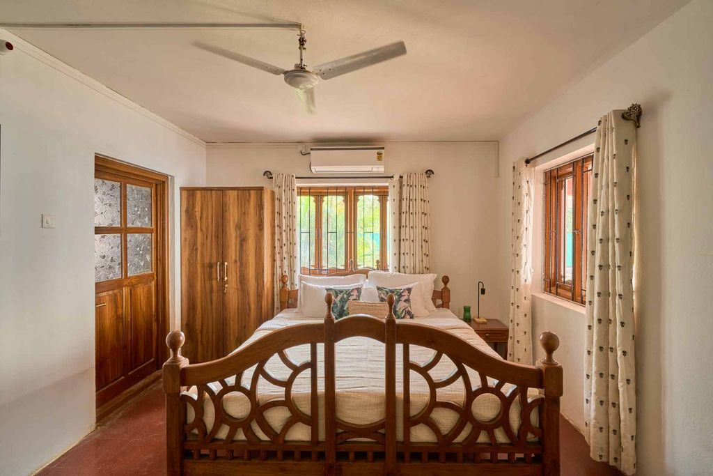 Bedroom with a carved wooden bed and wardrobe