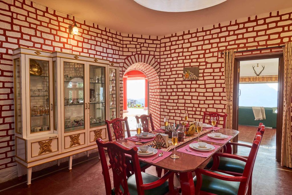 Dining table set beside an arched doorway to the lawn